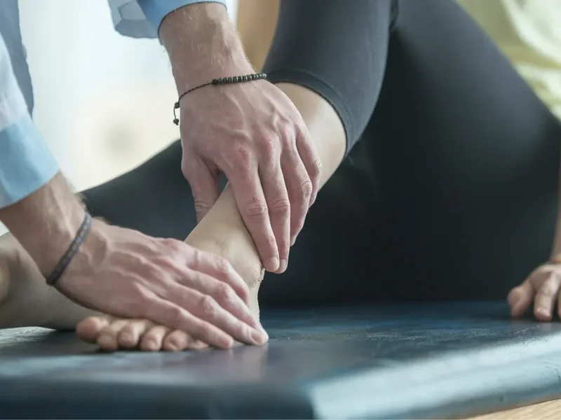 Physical therapist assessing a patient's foot and ankle mobility and strength
