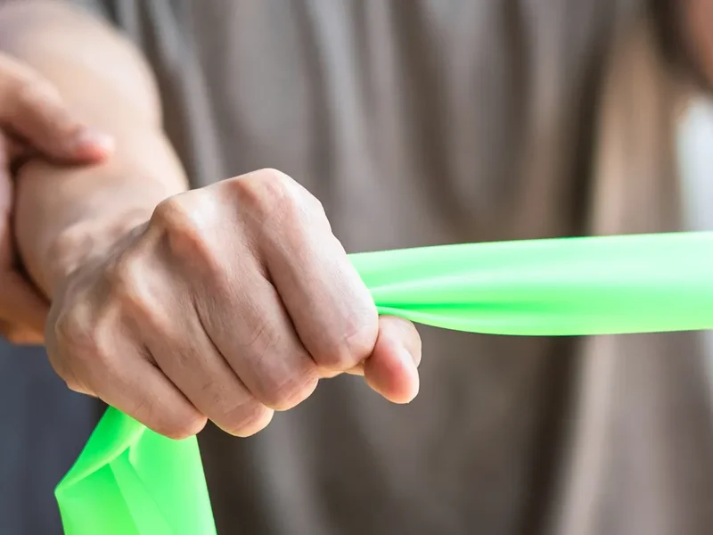Person performing a wrist strengthening exercise with a resistance band
