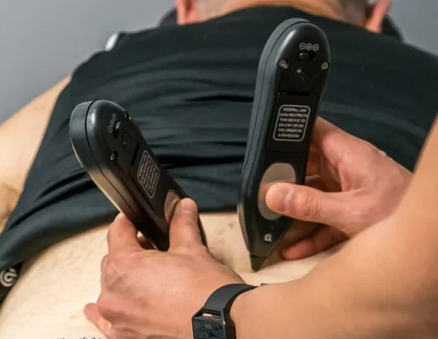 Doctor of Physical Therapy using soft tissue instruments on a patient's back